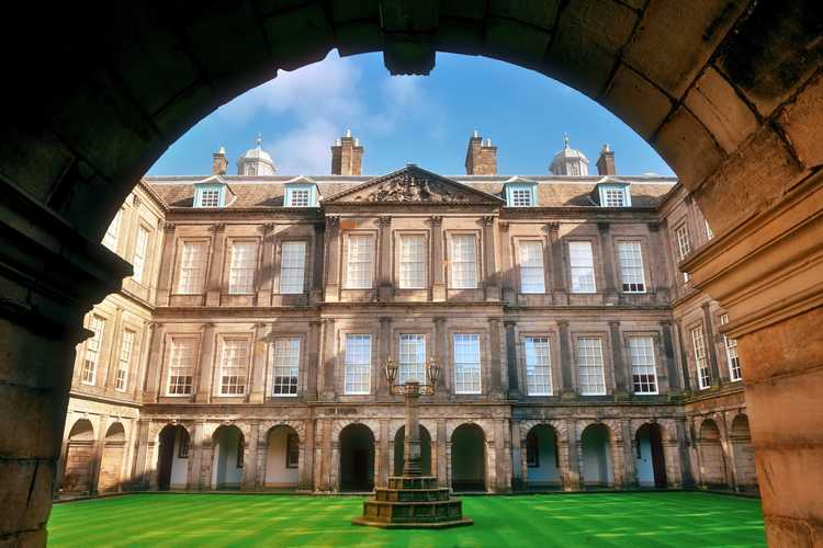 Beautiful symmetrical architecture of the inner courtyard quadrangle at the Palace of Holyroodhouse with a pristine green lawn in Edinburgh
